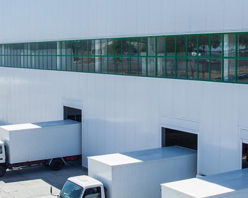 facade of an industrial building and warehouse with freight cars in length-banner