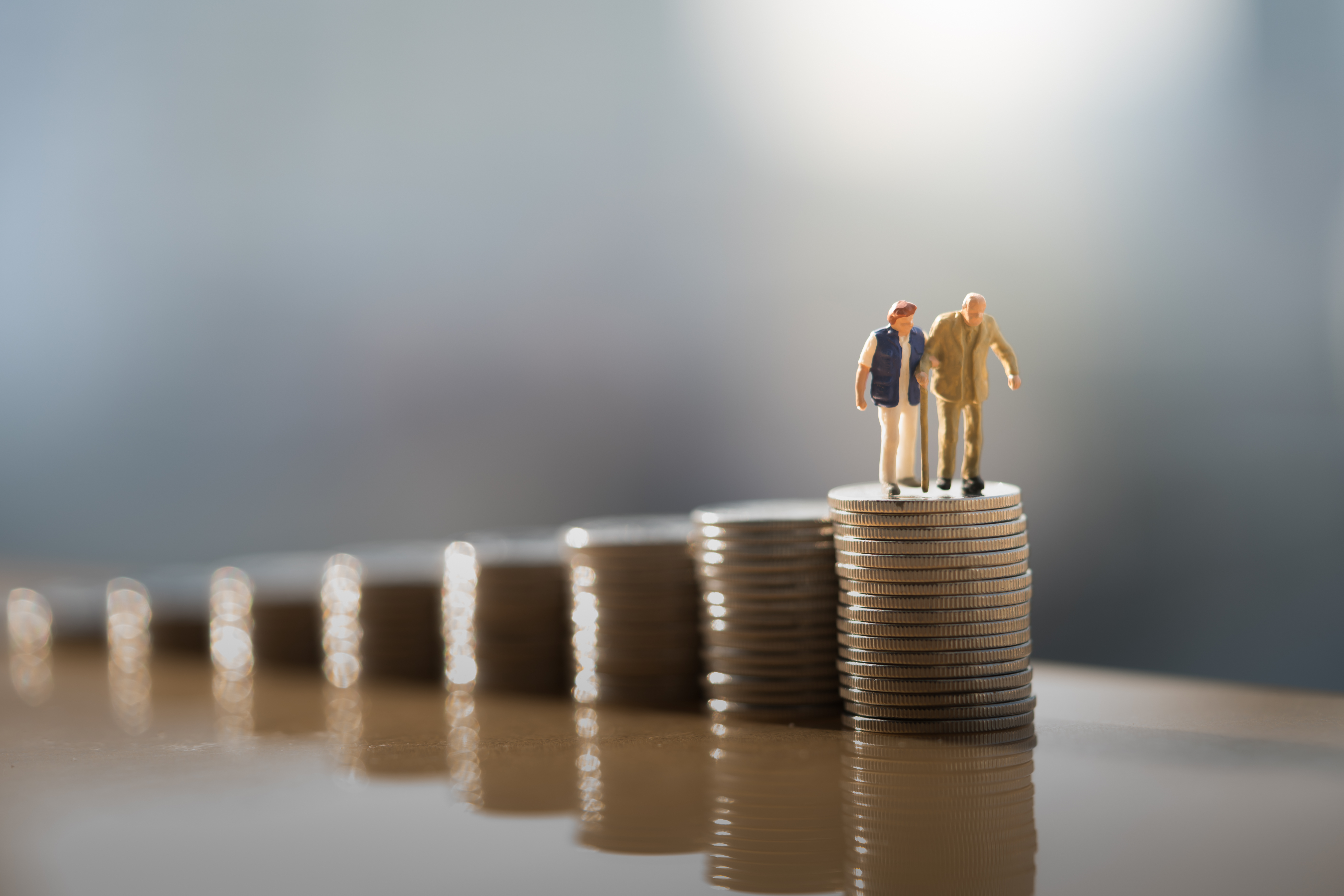 An image depicting a retired couple navigating retirement risks by jumping from one stack of coins to a higher stack of coins